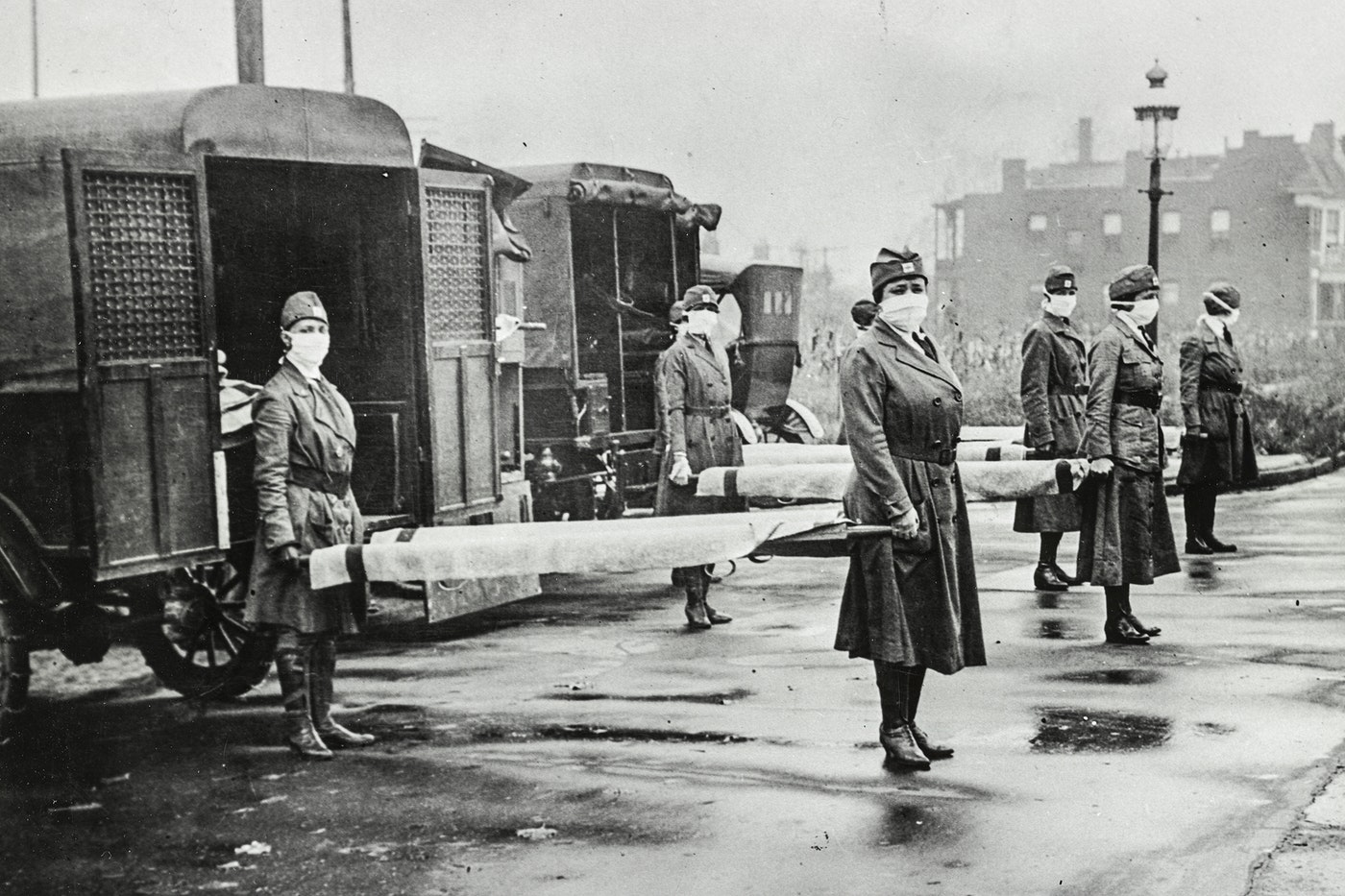 1918 influenza epidemic St. Louis Red Cross Motor Corps personnel wear masks as they hold stretchers next to ambulances in preparation for victims of the influenza epidemic in October 1918. (Library of Congress)